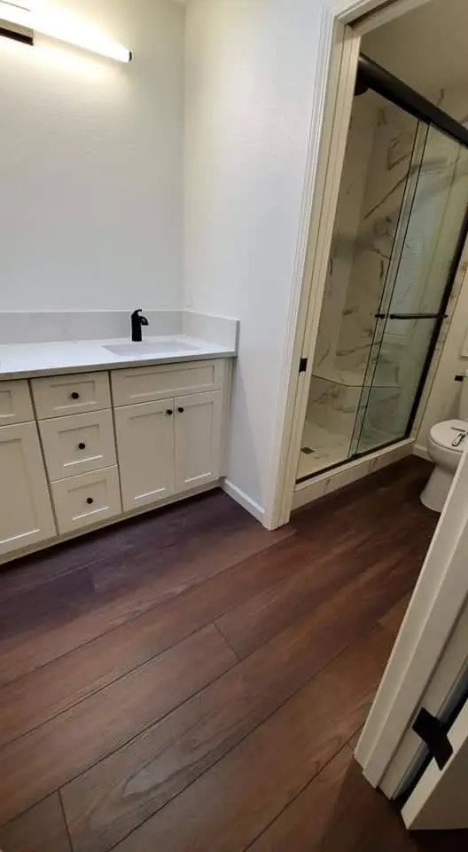 Bathroom vanity with shaker cabinets and glass shower