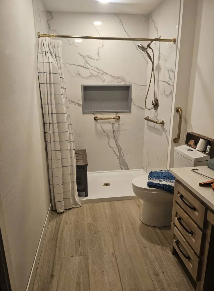 Accessible shower with marble tile and grab bars