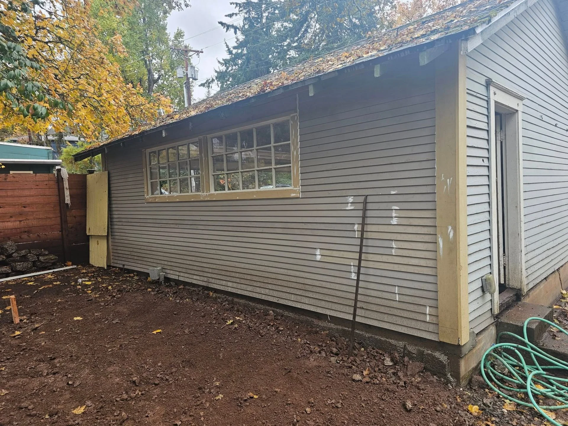 Garage exterior with repaired siding ready for paint